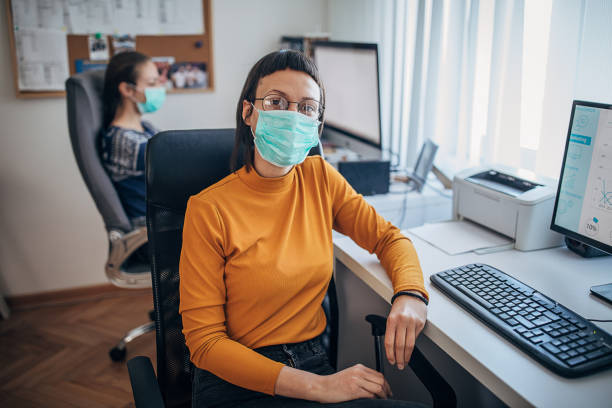 istock Woman with protective mask sitting in office 1226038985