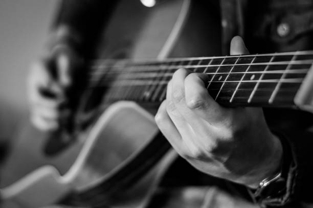 istock Guitar player chords close up on the strings - black and white, selective focus. 1226041235