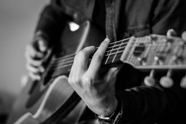 istock Guitar player chords close up on the strings - black and white, selective focus. 1226041298