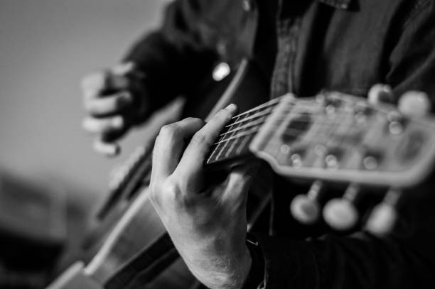 istock Guitar player chords close up on the strings - black and white, selective focus. 1226041328