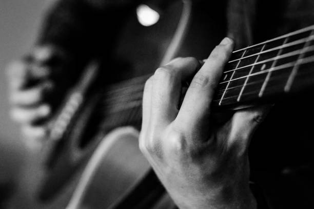 istock Guitar player chords close up on the strings - black and white, selective focus. 1226041330
