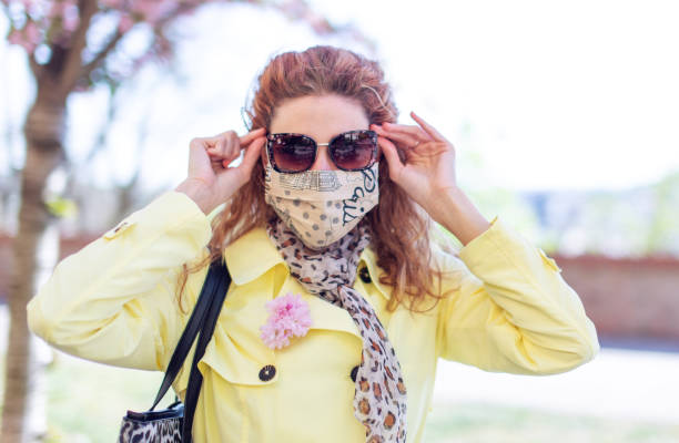 istock Young redhead woman in mask holding sunglasses at springtime 1226041396