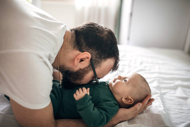 istock Father playing with his baby son on bed at home 1226043415