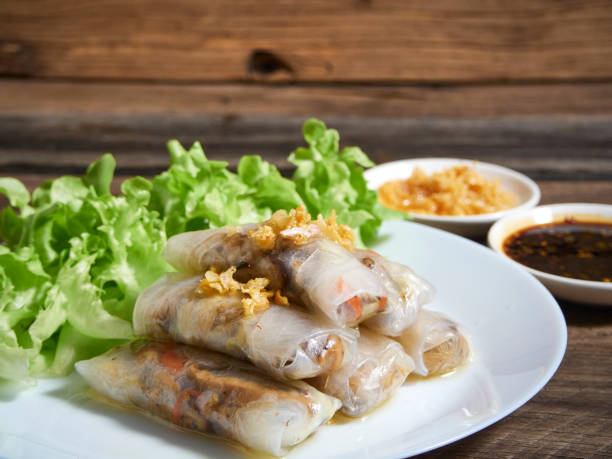 istock Spring rolls and rice paper on wooden table top in the kitchen. 1226044279