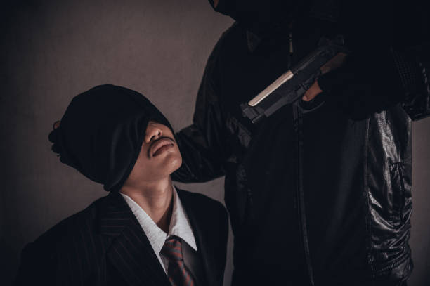 istock A terrorist man holding gun kidnapping young women for a hostage in abandoned building. 1226044347