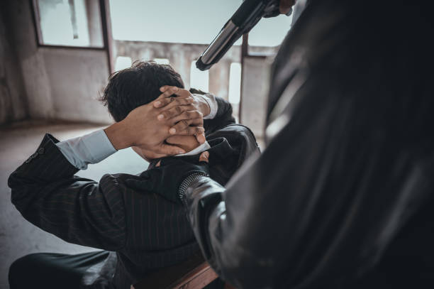 un uomo terrorista che tiene in braccio una pistola che rapise giovani donne per un ostaggio in un edificio abbandonato. - thief crime gun hostage foto e immagini stock