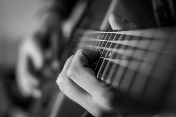 istock Guitar player chords close up on the strings - black and white, selective focus. 1226047071