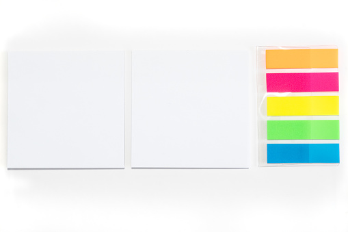 Two White sticky note and different colored sheets of note papers isolated on white background.