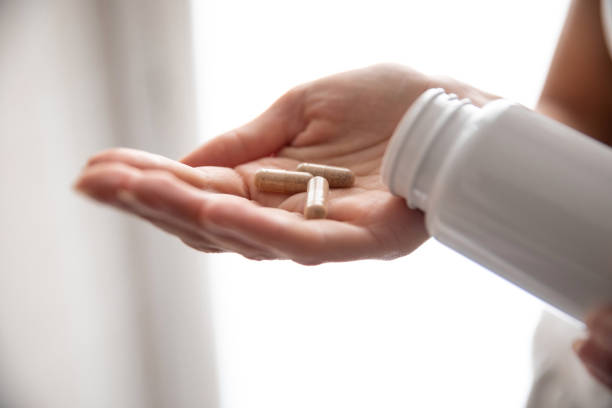 istock Young woman taking supplements at home 1226050591