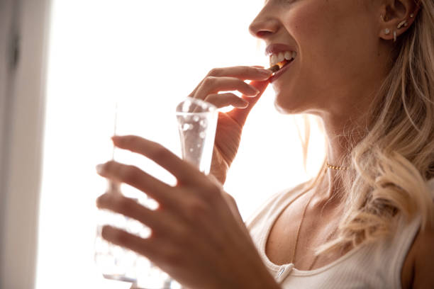 istock Young woman taking supplements at home 1226050595
