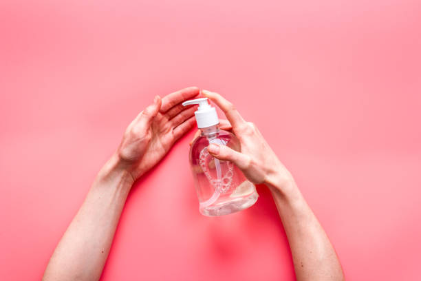 istock Disinfecting hands. Dispensing sanitizer on pink background top view 1226053104