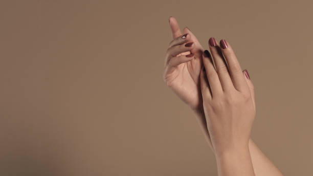 istock Female beautiful hands with painted red nails on beige color background with copy space 1226053376