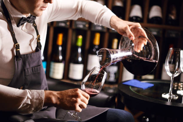 istock Expert decanting and pouring wine into glass. Staff training for sommelier 1226058406
