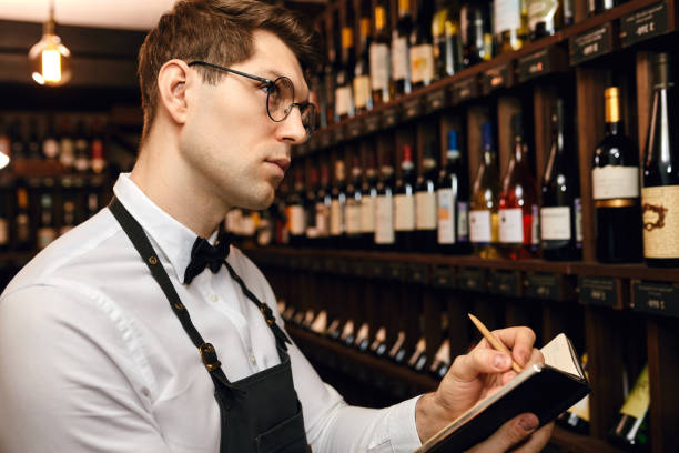 istock Sommelier putting down information of wine products in wine store 1226059111