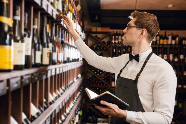 istock Sommelier writes at notes, putting down information on wine products in cellar 1226059150