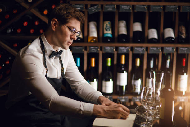 istock Wine taster writing in notepad information of wine origin and taste. 1226059182