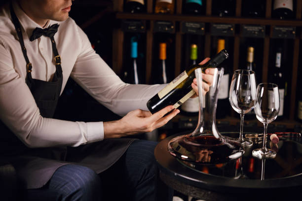 istock Wine steward looking at bottles of wine and writing in notebook at wine cellar 1226059186