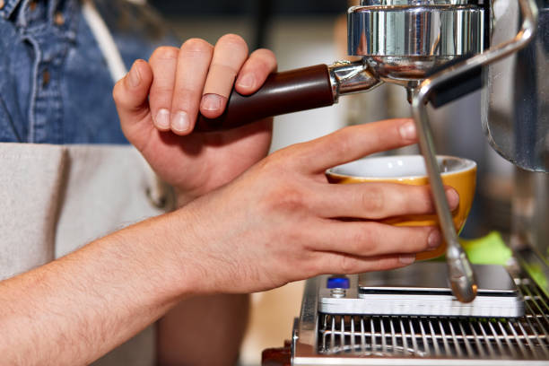 Handsome barman preparing ground coffee for customer in coffee shop.
