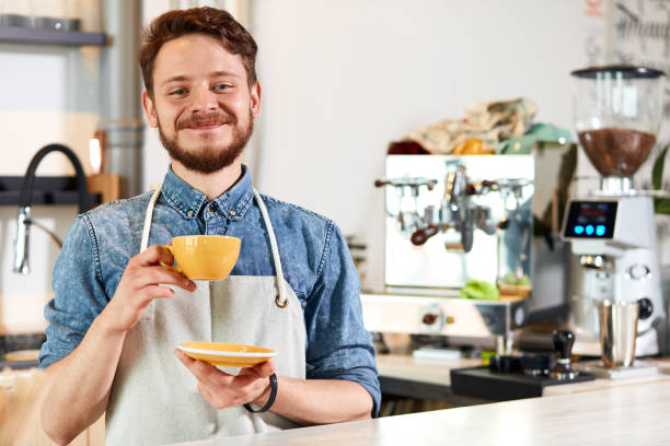 istock Portrait of joyful bartender standing at bar counter 1226061037
