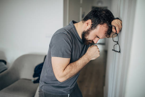 istock Man with Covid-19 symptoms coughing at home 1226061091