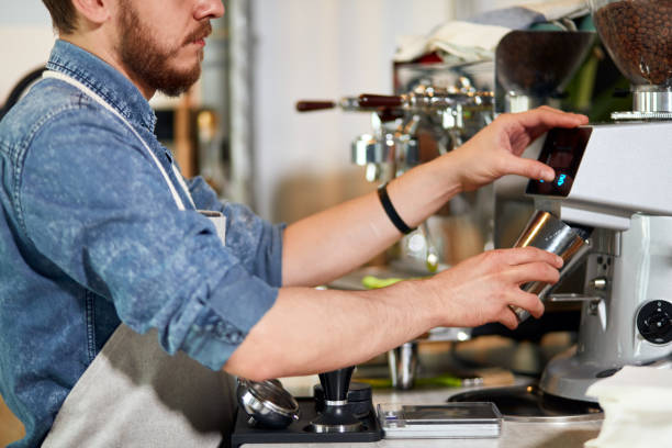 istock Young bearded man standing near coffee machine 1226061188