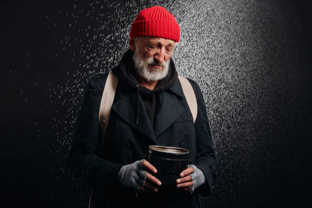 istock Bum with grey beard stand under heavy rain with cup for money 1226061304