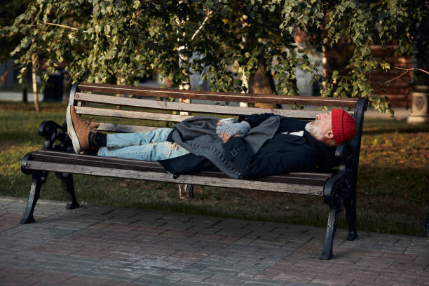 istock Beggar male sleeping on bench during the day 1226061411