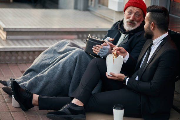 senior caucasian beggar male telling story about life to businessman - smoking issues fotos imagens e fotografias de stock