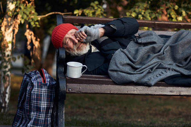 istock old man lying on bench in city park in cold weather 1226063720