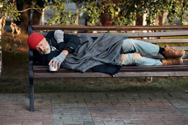 istock Poor homeless man lying on bench in cold weather 1226064125