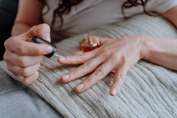 Woman polishing her nails at home stock photo