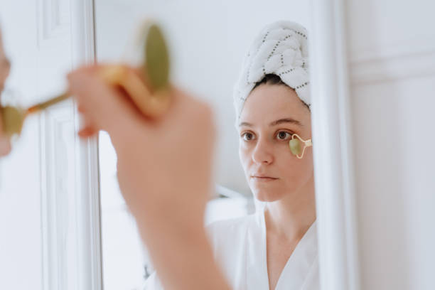 istock Woman using jade roller on her face at home 1226065248