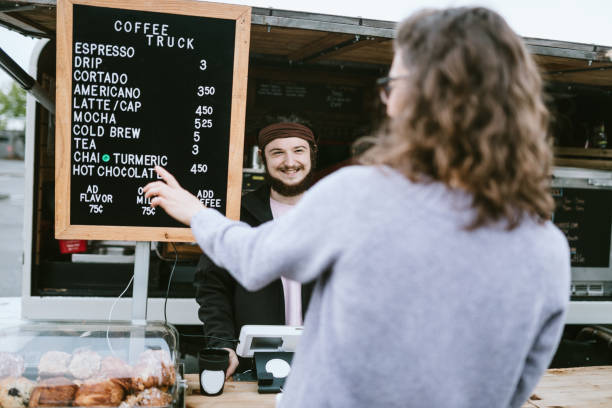 istock Cheerful Mobile Coffee Truck Employee Takes Customers Order 1226065698
