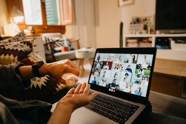 istock Woman is using hand sanitizer while she's having a video call with many people on her laptop 1226067187