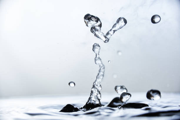 istock Boiling water splash with steam on blue background closeup 1226067247