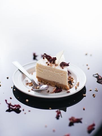 Slice of cheesecake on a black background with nuts