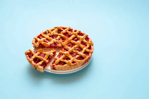 Photo of Rhubarb pie with a lattice crust on a plate. Sliced sweet pie