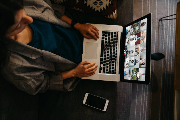 Young woman using a laptop on the sofa at home to have a work conference call