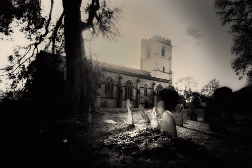 Black and white image image of the church and churchyard at Netherbury, Dorset, UK