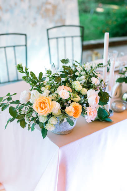 istock Vertical frame festive setting of the wedding table for seating guests at the welcome dinner with a central composition of flowers, candlesticks 1226072550