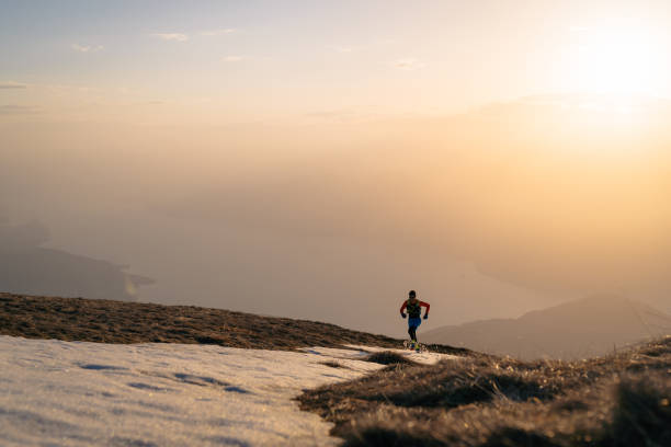 istock Young man trail runs up mountain at sunrise 1226073407