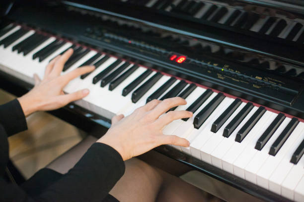 istock Crop of hands playing on piano from side perspective 1226073493