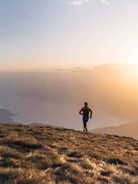 istock Young man trail runs up mountain at sunrise 1226074603