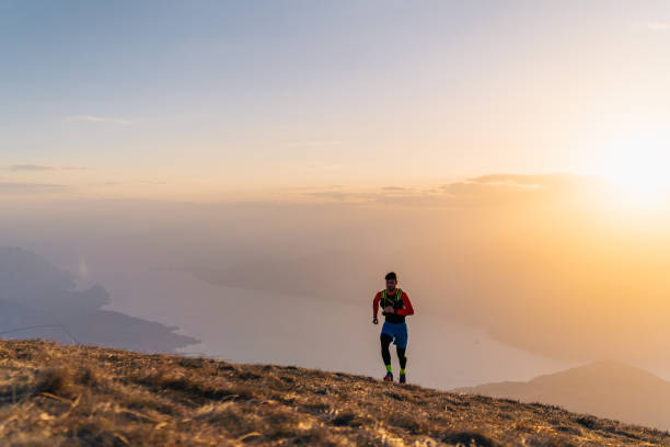 istock Young man trail runs up mountain at sunrise 1226074642