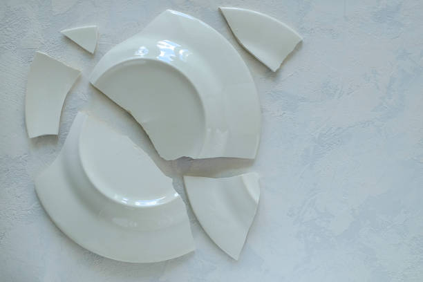 istock Shards of broken white porcelain plate on a light surface. 1226074848