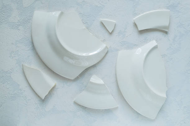 istock Shards of broken white porcelain plate on a light surface. 1226074925