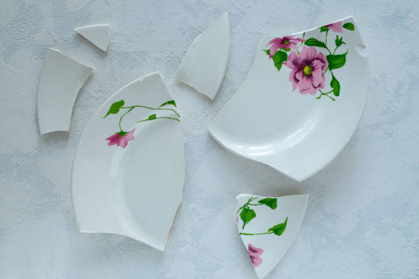 istock Shards of broken white porcelain plate on a light surface. 1226074981