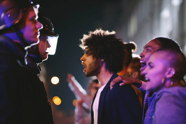 istock Angry protestors protesting in front of police force 1226074990