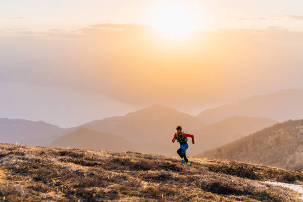 istock Young man trail runs up mountain at sunrise 1226075056