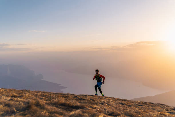 istock Young man trail runs up mountain at sunrise 1226075217